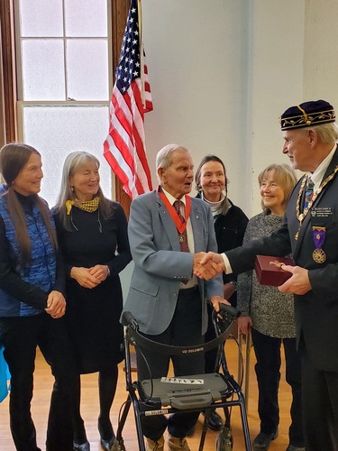 Richard H. Hamilton shakes hands with William Basso II, Representative of the Scottish Rite, upon receiving the Tompkins Award. Looking on are Hamilton’s daughters, from left, Karla Bills, Barbara Giard, Becky Mrozcek, and Marcia Hamilton.