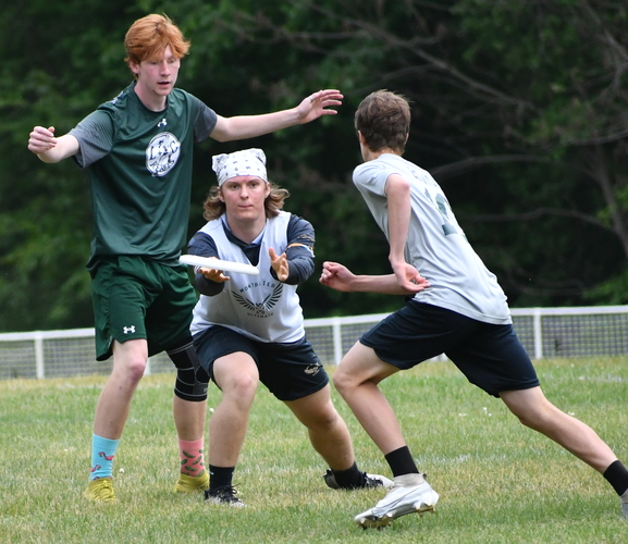 Leland & Gray’s Trevor Stillwagon, left, moves in to defend as Montpelier’s Cale Ellingson (center) takes a pass from a teammate during their Ultimate disc state quarterfinal match on June 5 in Townshend.