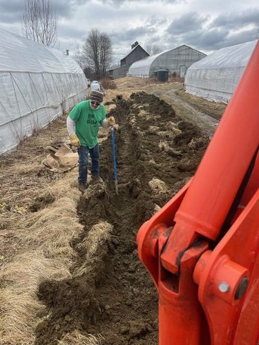 Twenty-year employee Richard Fairchild works creating a ditch for a new tunnel to protect crops from high heat in the summer and cold weather in the spring.  Farmer Howie Prussack says these tunnels provide more protection for his crops as climate change gives farmers more to worry about.
