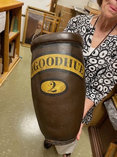 Brooks Memorial Library Director Starr LaTronica holds a leather bucket used by the Brattleboro Fire Department in the 1800s.