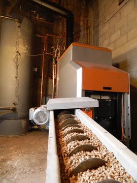   Wood pellets are fed into the EvoWorld boiler at the Vermont Farmer’s Food Center in Rutland.