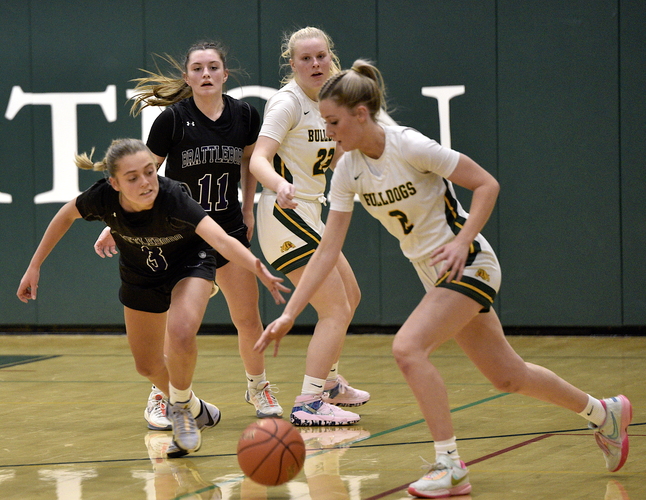 Brattleboro guard Abby Henry (3) reaches in to try and steal the ball from Burr & Burton guard Ainerose Souza (2) during the first half of their girls’ basketball game in Townshend on Dec. 8. Looking on are Brattleboro guard Kate Pattison (11) and Burr & Burton guard Macy Mathews (23).