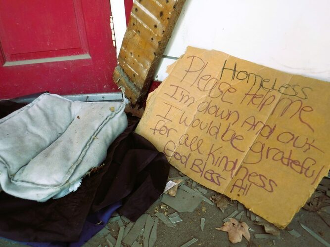 A sign and sleeping gear lies in a doorway in downtown Brattleboro.