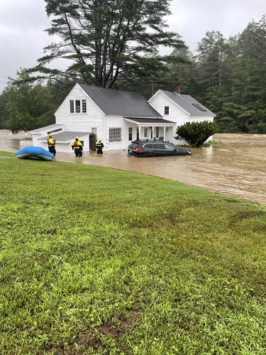 Members of Rescue Inc. Technical Rescue’s swift water team check on the residents of a home in Londonderry as flood waters continue to rise on July 10.
