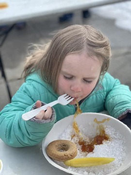 A young carnivalgoer enjoys sugar on snow, served just as it has been served for 68 years.