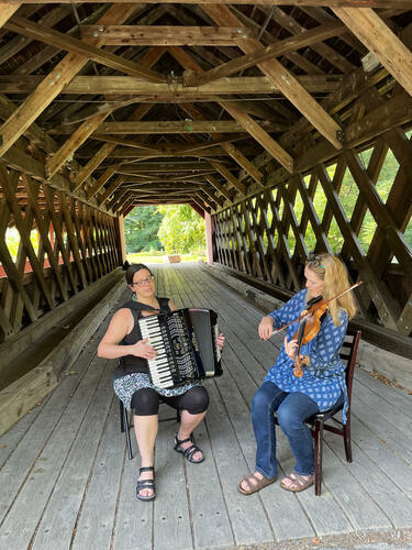 Rachel Bell on accordion and Becky Tracy on fiddle rehearse at the Creamery Covered Bridge in Brattleboro for their upcoming benefit community dance at Scott Farm Orchard in Dummerston.
