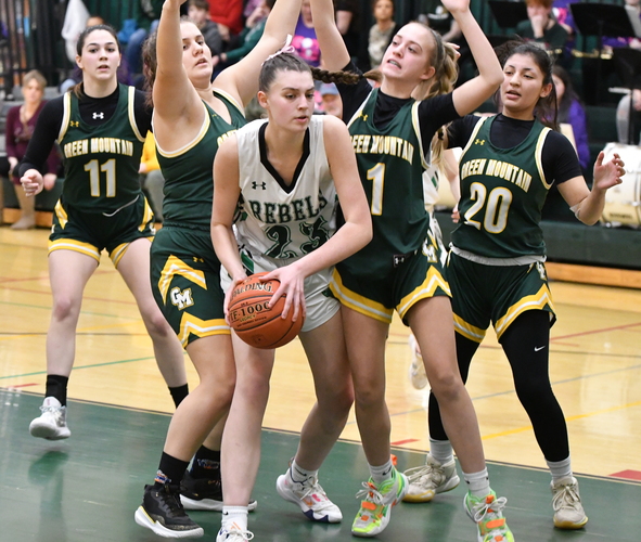 Leland & Gray forward Hannah Greenwood (23) is surrounded by Green Mountain defenders Luna Burkland, Colie Roby (1), and Karen Vargas (20) as she secures a rebound during the second half of their girls’ basketball game on Feb. 10 in Townshend.